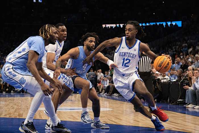 Dec 16, 2023; Atlanta, Georgia, USA; Kentucky Wildcats guard Antonio Reeves (12) dribbles the ball against North Carolina Tar Heels guard RJ Davis (4) and forward Jae'Lyn Withers (24) during the first half at State Farm Arena. Mandatory Credit: Jordan Godfree-USA TODAY Sports